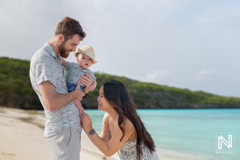 Family and friends enjoying a memorable photoshoot at the beach in Curacao with a baby under a sunny sky