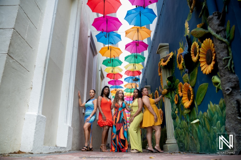 Family and friends gather in Curacao for a fun photoshoot under colorful umbrellas and bright murals