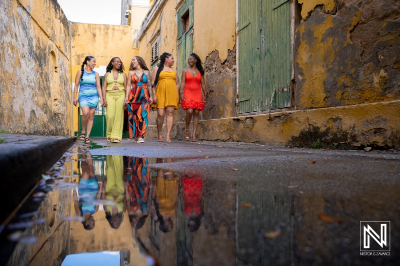 Family and friends enjoy a fun vacation photoshoot in the colorful streets of Curacao on a sunny day