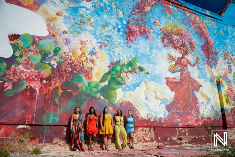 Family gathering in Curacao against a colorful mural in a sunny vacation setting