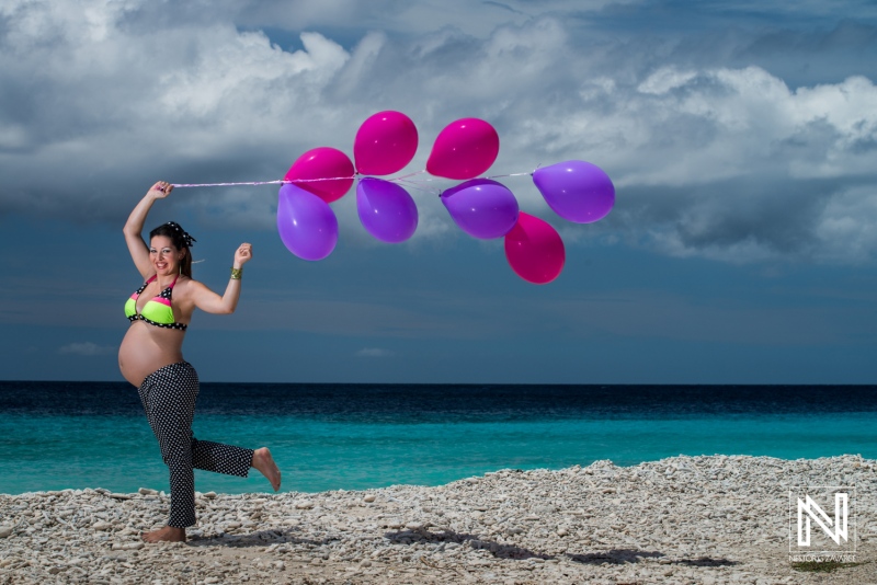 Expecting joy in Curacao with colorful balloons during a beautiful maternity photoshoot by the beach