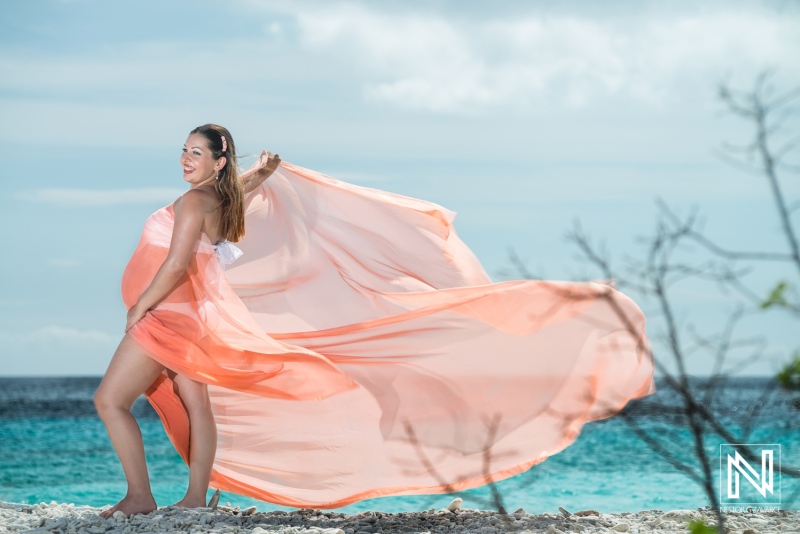 Pregnant woman in maternity dress enjoying the beach in Curacao during a sunny day