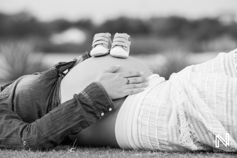 Maternity shoot in Curacao featuring expectant mother with baby shoes on her baby bump