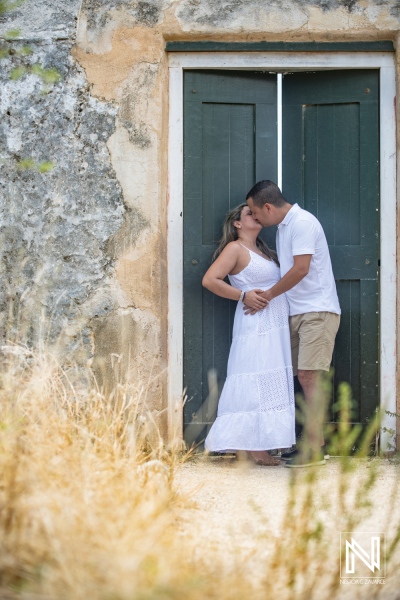 Couple shares a tender moment during a maternity shoot in Curacao surrounded by natural beauty and warm sunlight