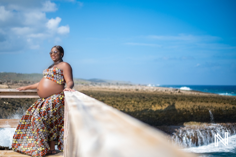 Beautiful pregnant woman in colorful dress enjoying the coastal views of Curacao under a clear blue sky