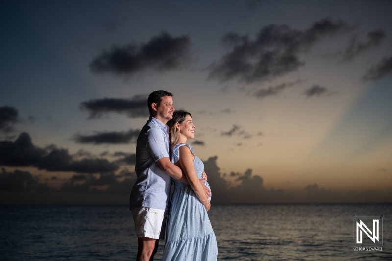 Expecting joy in Curacao as a couple embraces pregnancy at sunset by the tranquil sea