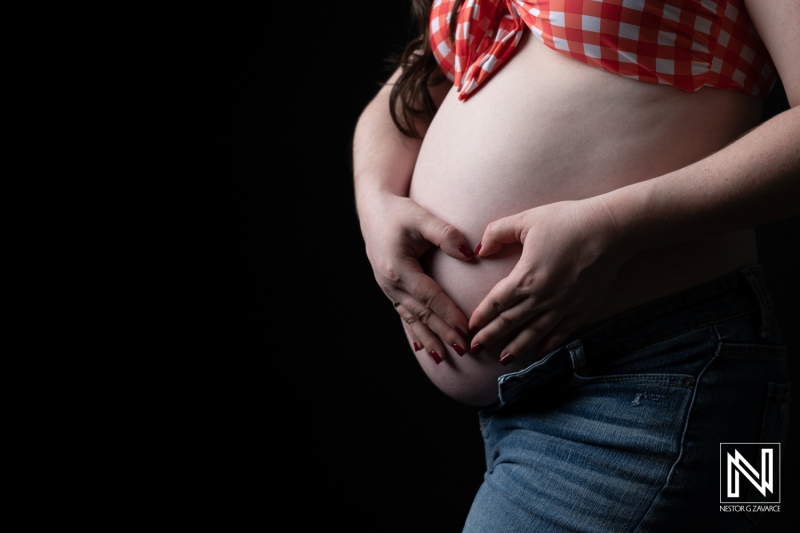 Celebrating maternity in Curacao with a person gently cradling their pregnant belly in a heartfelt gesture