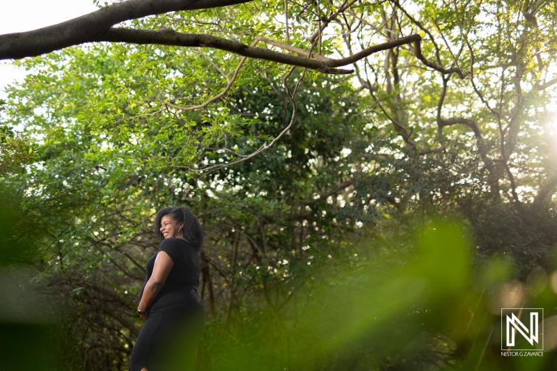 Curacao matron enjoying serene moments in nature during pregnancy while surrounded by lush greenery in golden sunlight