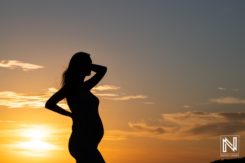 Expecting mother poses at sunset during maternity photoshoot at Playa Porto Mari in Curacao