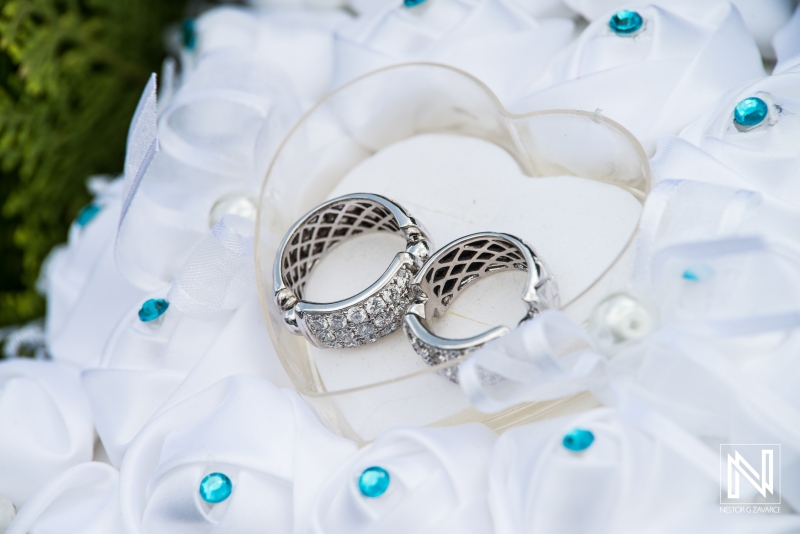 Wedding rings inside heart box on cusion