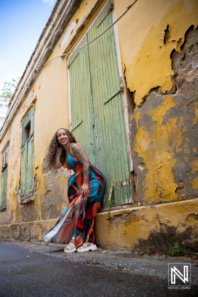 Portrait photoshoot in Curacao with a person near a yellow wall and green doors