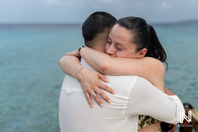 Romantic wedding proposal taking place on beautiful Kokomo Beach in Curacao with emotional embrace and joy shared by the couple