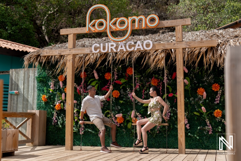 Couple enjoys a romantic moment at Kokomo Beach during a wedding proposal in Curacao with tropical scenery and vibrant decorations