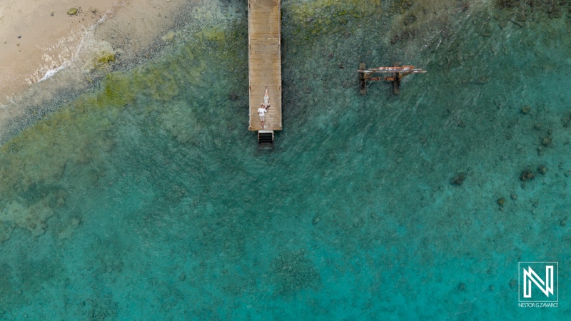 Proposal on the dock at Kokomo Beach in Curacao under clear blue waters and sky