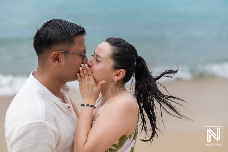 Couple shares an intimate moment during a wedding proposal at Kokomo Beach in Curacao under a beautiful sky and gentle waves
