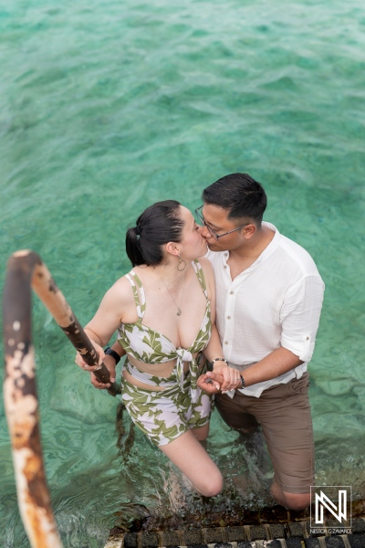 Couple shares a romantic kiss during a wedding proposal at Kokomo Beach in Curacao surrounded by turquoise waters
