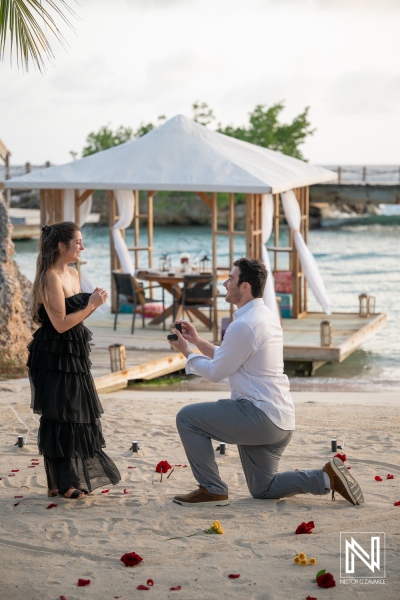 Couple enjoys wedding proposal at Baoase Luxury Resort in Curacao with flowers and a beach setting
