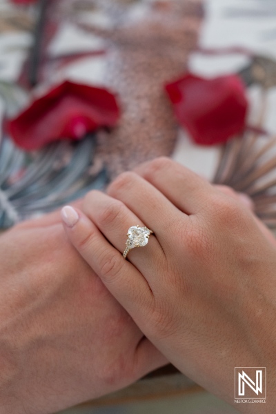 Romantic wedding proposal at sunset in Curacao's Baoase Luxury Resort surrounded by rose petals