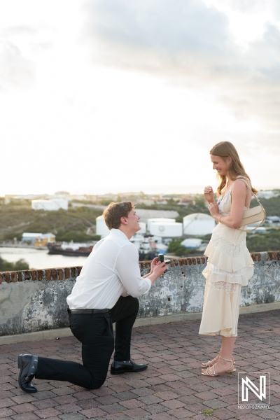 Couple celebrates wedding proposal at Fort Nassau during sunset in Curacao with beautiful views of the island
