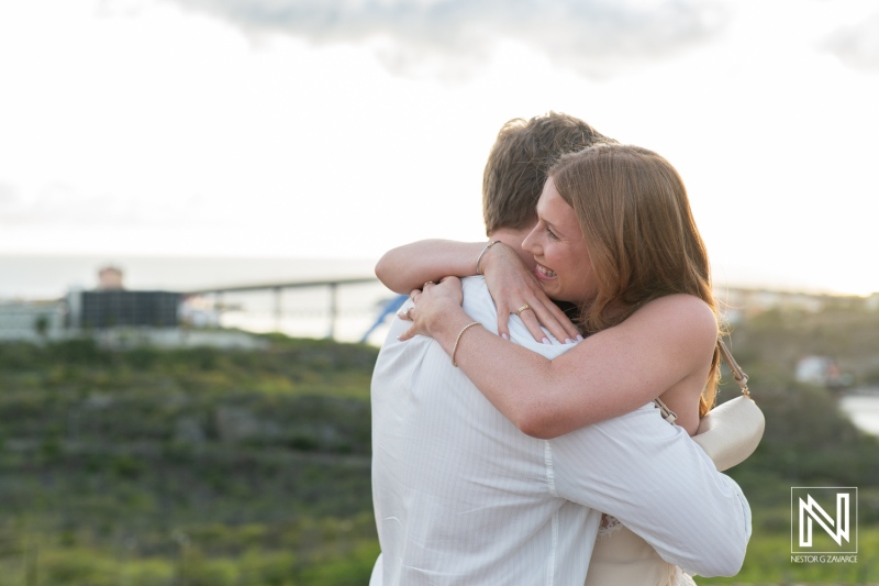 Couple embraces after wedding proposal at Fort Nassau in Curacao during sunset