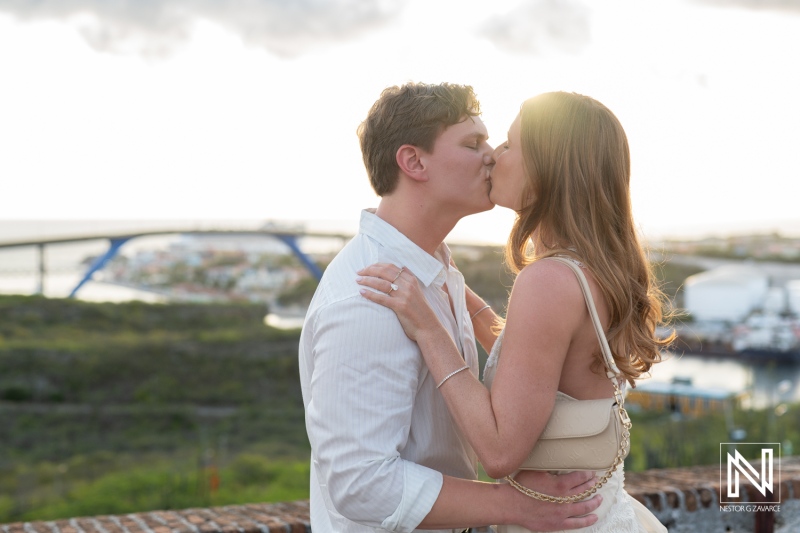 Couple shares a kiss during a wedding proposal at Fort Nassau in Curacao during sunset