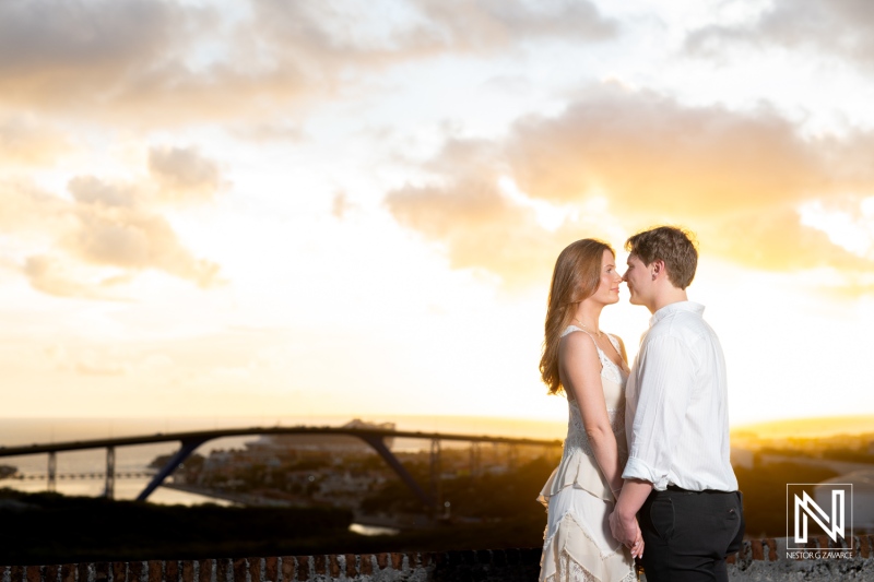 Couple shares a wedding proposal moment at Fort Nassau in Curacao during sunset