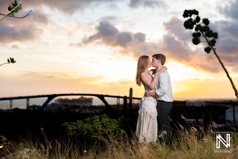 Couple shares a special moment during a wedding proposal at Fort Nassau in Curacao as the sun sets in the background