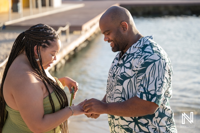 Couple engages in wedding proposal at Avila Beach Hotel in Curacao during sunset by the water