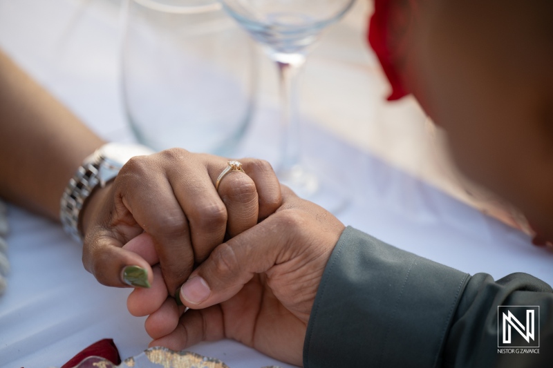 Couple holds hands during wedding proposal at Avila Beach Hotel in Curacao near sunset