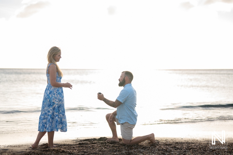 Couple enjoys romantic sunset proposal at Playa Jeremi beach in Curacao, capturing a special moment filled with love and joy
