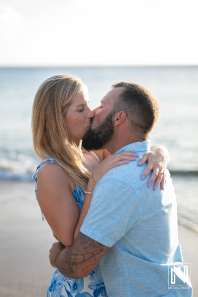 Romantic couple shares a kiss during a wedding proposal at Playa Jeremi, Curacao at sunset, capturing the essence of love