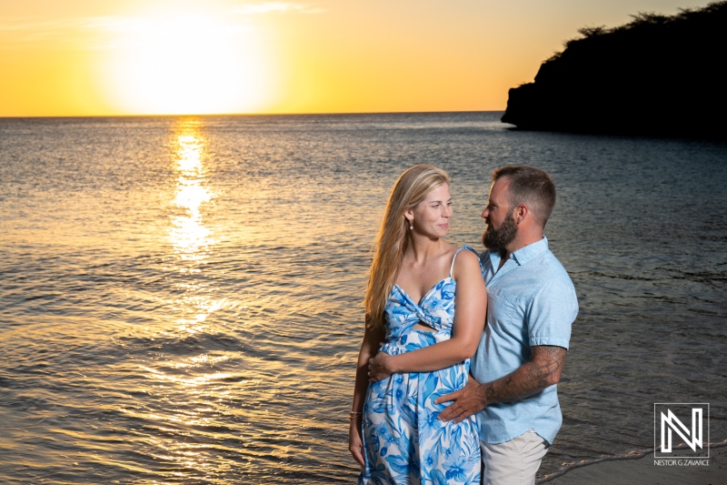 Couple captures special moment during sunset wedding proposal at Playa Jeremi in Curacao near shimmering waters