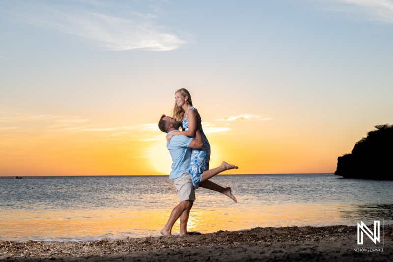 Couple enjoys a romantic wedding proposal at sunset on Playa Jeremi in Curacao, capturing a beautiful moment together