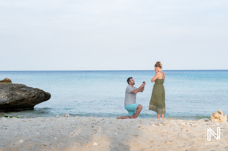 Couple enjoys a romantic wedding proposal at Daaibooi Beach in Curacao during a beautiful sunrise