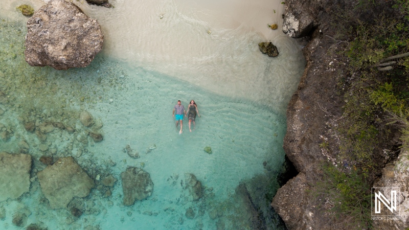 Couple experiences a romantic wedding proposal at Daaibooi Beach in Curacao during a stunning sunrise