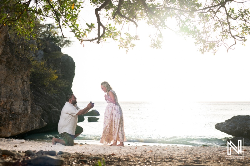 A couple enjoys a romantic beach proposal during sunset at a secluded coastal location, celebrating love and commitment in a picturesque setting