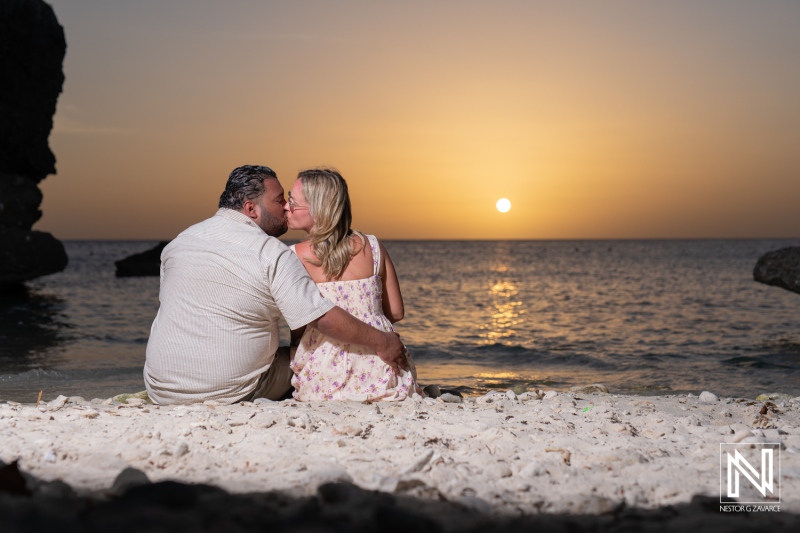 Romantic couple enjoying a sunset kiss on the beach in a tropical location, with the sun setting over the ocean in the background during a warm evening