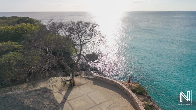 Couple has wedding proposal at Knip beach in Curacao during sunset by the water's edge