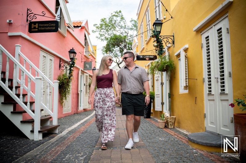 Couple enjoys a wedding proposal moment while walking in Willemstad, Curacao during bright daylight