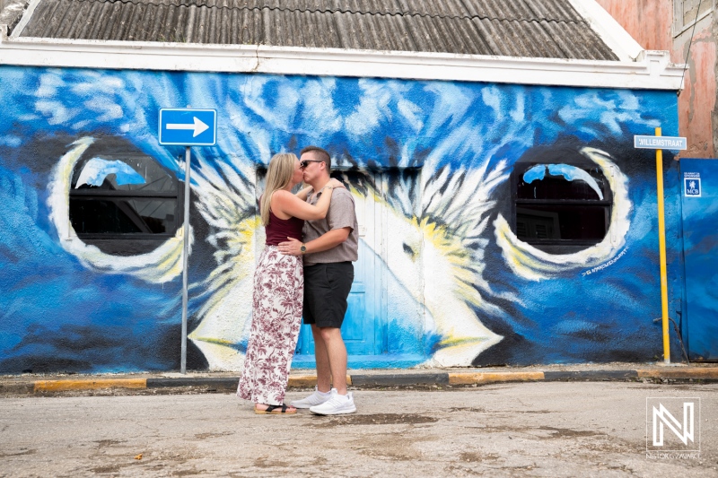Couple celebrates wedding proposal at Willemstad in Curacao under a colorful mural