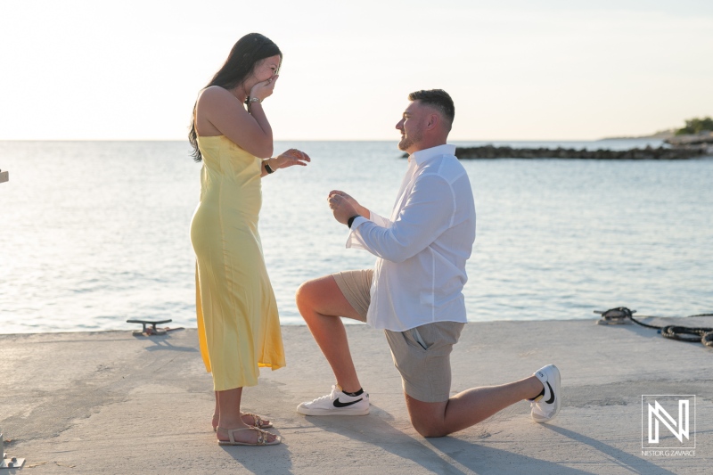 Romantic wedding proposal at sunset on the beach in Curacao with a stunning backdrop of the Marriott Beach Resort