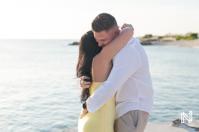 Couple celebrates romantic wedding proposal on the beach at Curacao Marriott Beach Resort during sunset