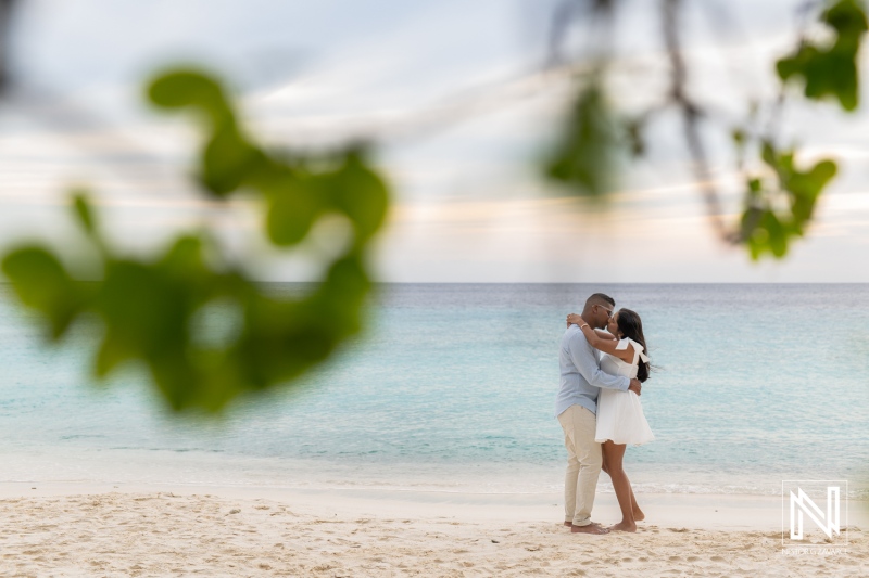 Couple shares a wedding proposal moment at Cas Abao Beach in Curacao at sunset with clear skies and soft waves