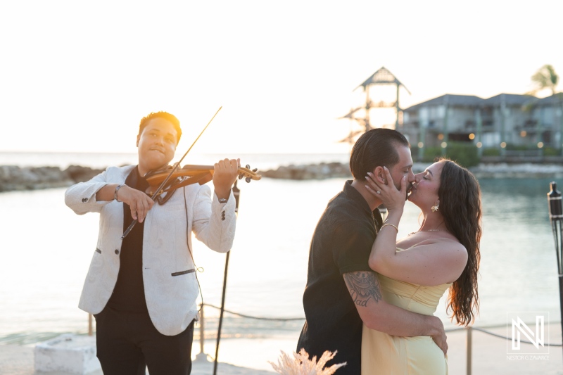 Couple shares romantic kiss during wedding proposal at sunset at Avila Beach Hotel in Curacao