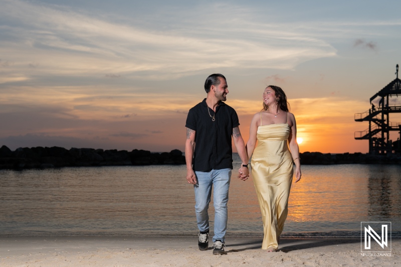 Couple enjoys a romantic sunset stroll after a wedding proposal at Avila Beach Hotel in Curacao