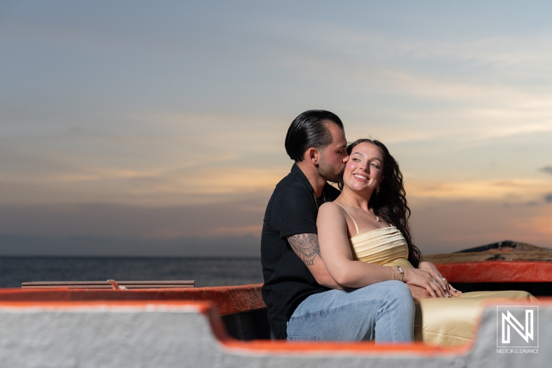 Romantic wedding proposal at Avila Beach Hotel in Curacao during a stunning sunset with a happy couple embracing