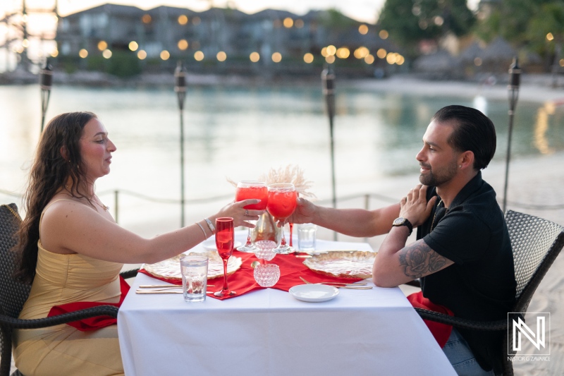 Couple celebrates romantic wedding proposal at sunset on the beach in Curacao