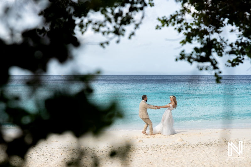 Couple Joyfully Dancing on a Picturesque Beach During Their Wedding Ceremony With the Ocean Waves Gently Lapping in the Background on a Sunny Day