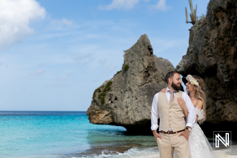 A Couple Celebrates Their Love at a Picturesque Beach on a Sunny Day, Surrounded by Cliffs and Sparkling Blue Water