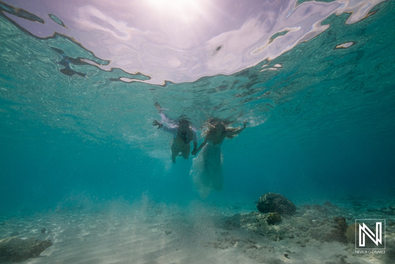 Two Individuals Swim Together in Crystal-Clear Turquoise Waters, Enjoying the Vibrant Underwater Scenery During a Sunny Day